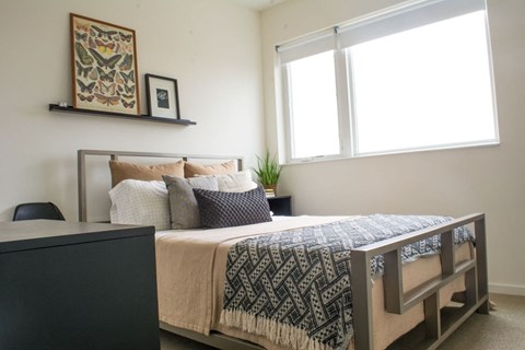a bedroom with a bed and a dresser and a window